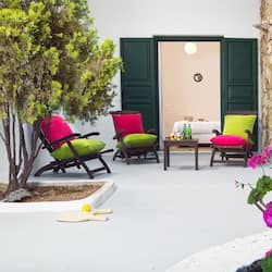 Relax in a serene outdoor space surrounded by lush greenery and comfortable seating.