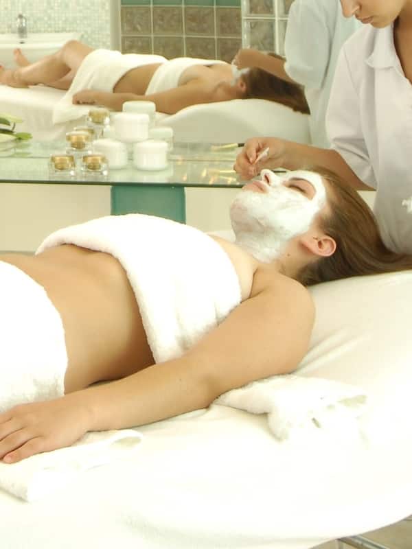 Experience rejuvenation in a serene spa setting with a treatment bed, practitioner, and tranquil ambiance.
