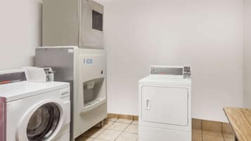 Un espace buanderie comprenant un lave-linge, un sèche-linge et un appareil à glaçons.