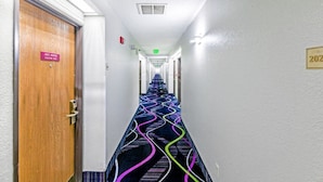 A hotel hallway with a patterned carpet, a door labeled "James Monroe Executive Suite," and an exit sign. - Baymont by Wyndham Jackson (Jackson)