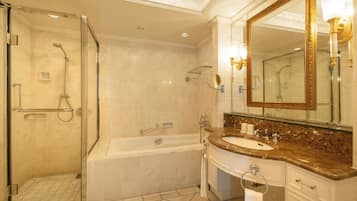 Een moderne badkamer met een glazen douchecabine, een vrijstaand bad en een marmeren wastafelmeubel met een grote spiegel.