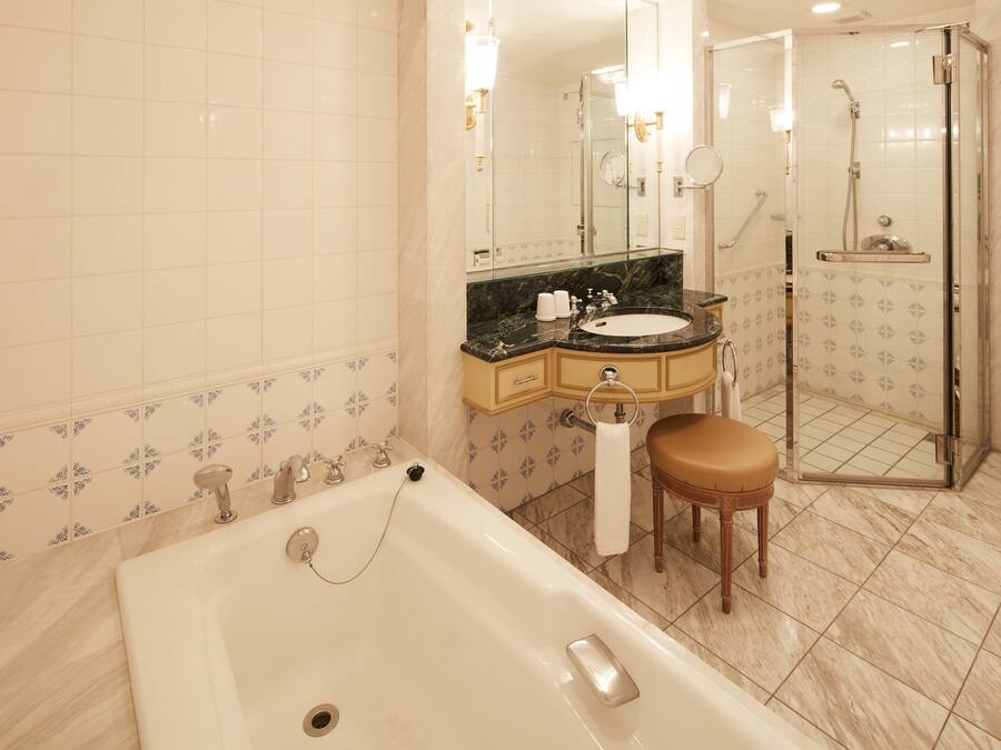 Ein Badezimmer mit Badewanne, Waschbecken, Spiegel und Duschbereich.
