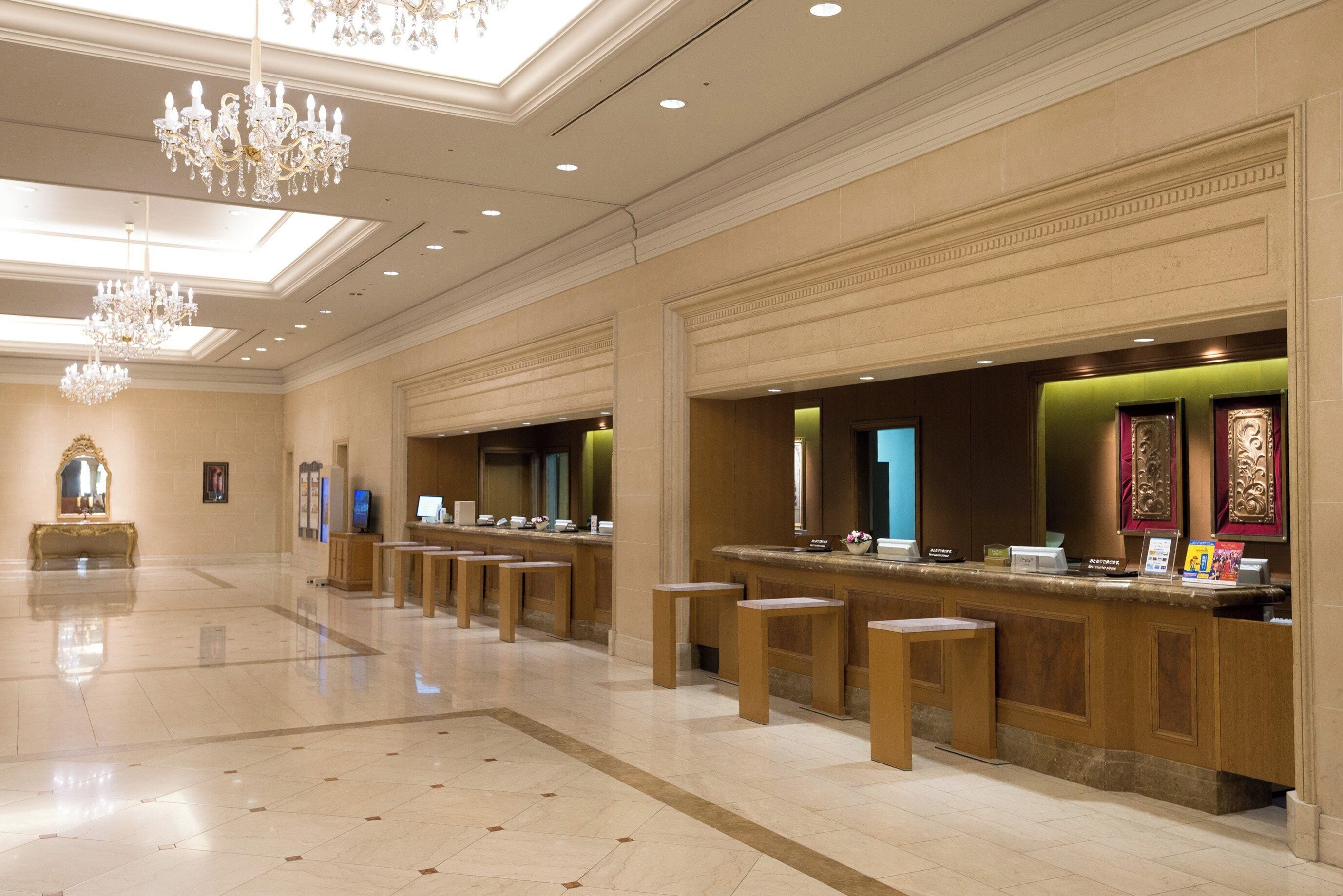 Eine Hotelhalle mit Empfangstresen, Sitzgelegenheiten und einer Kandelaber.