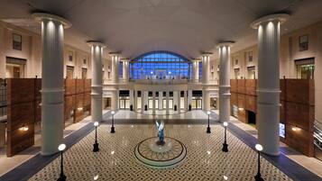 A spacious lobby with high ceilings, large columns, and a central circular light fixture.