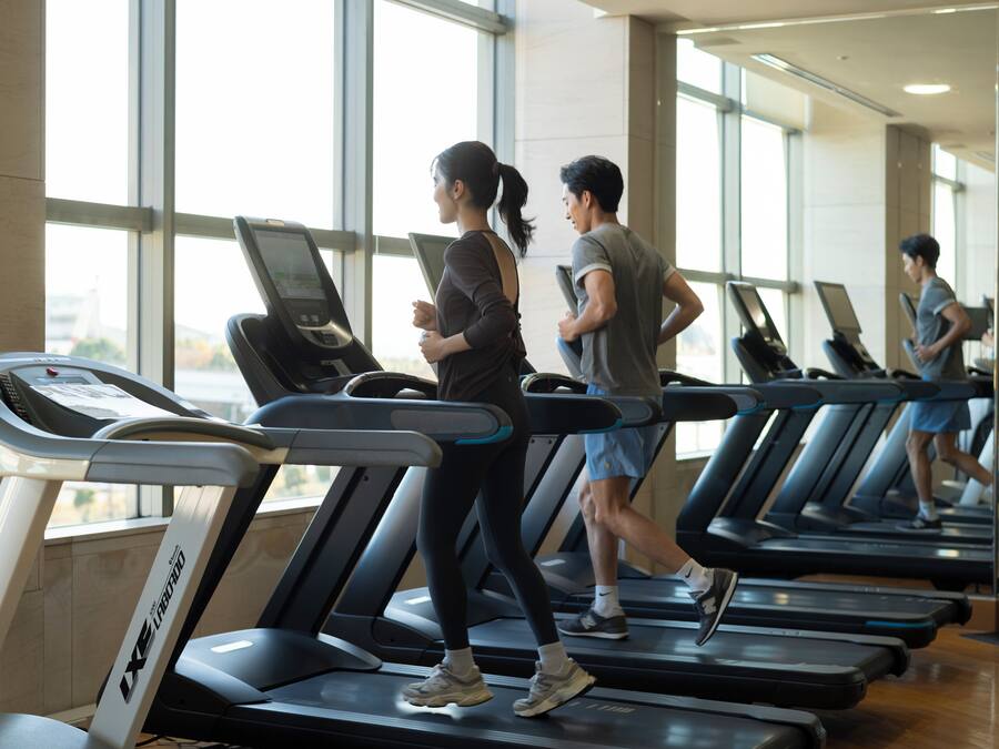 A gym with treadmills, large windows, and a modern interior.