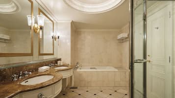 Une salle de bain avec deux lavabos, une baignoire et une douche à l’italienne.