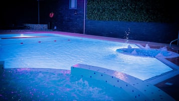 Una piscina techada, sillones reclinables de piscina