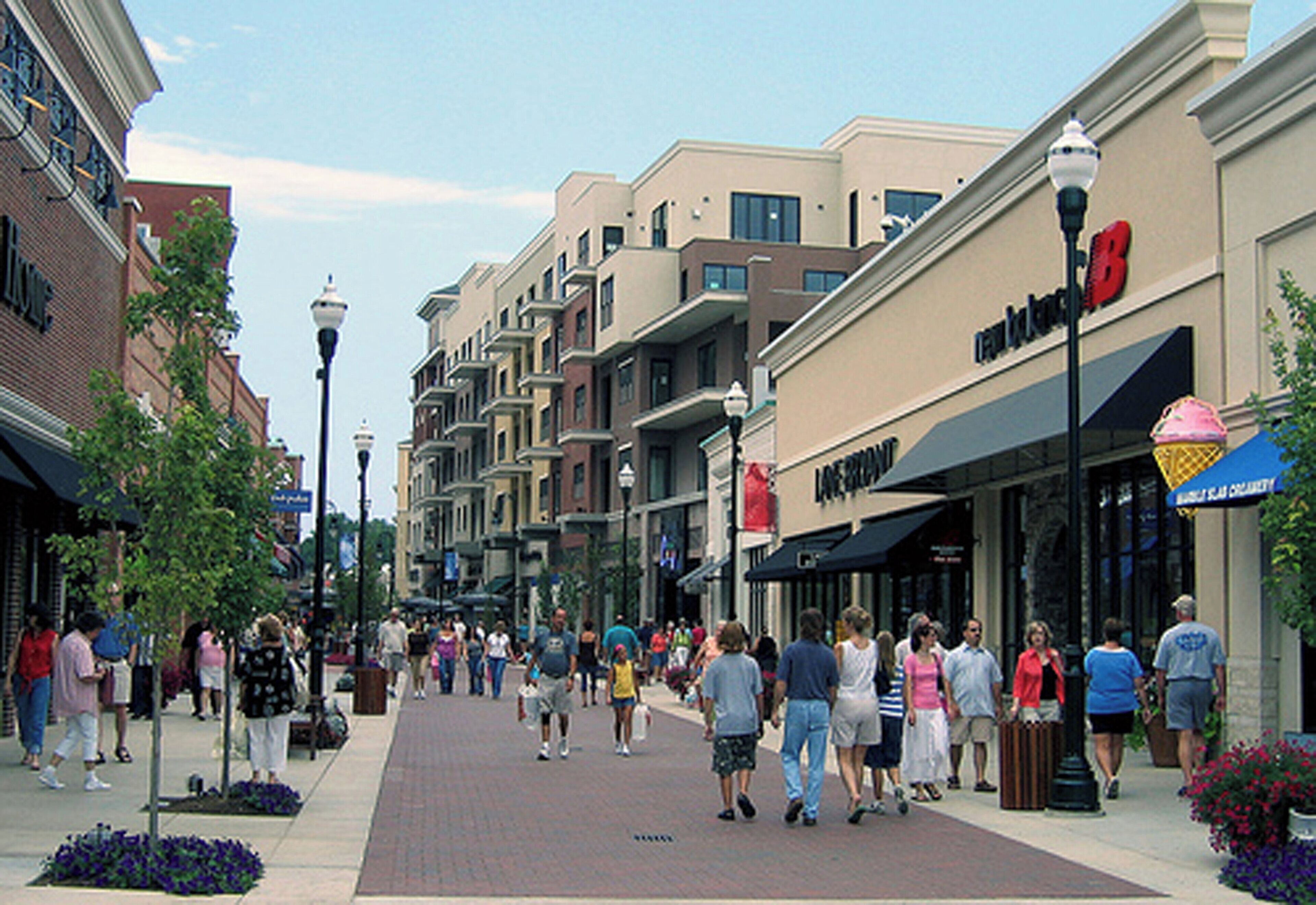 A pedestrian street lined with multi-story buildings, some with commercial establishments on the ground floor.