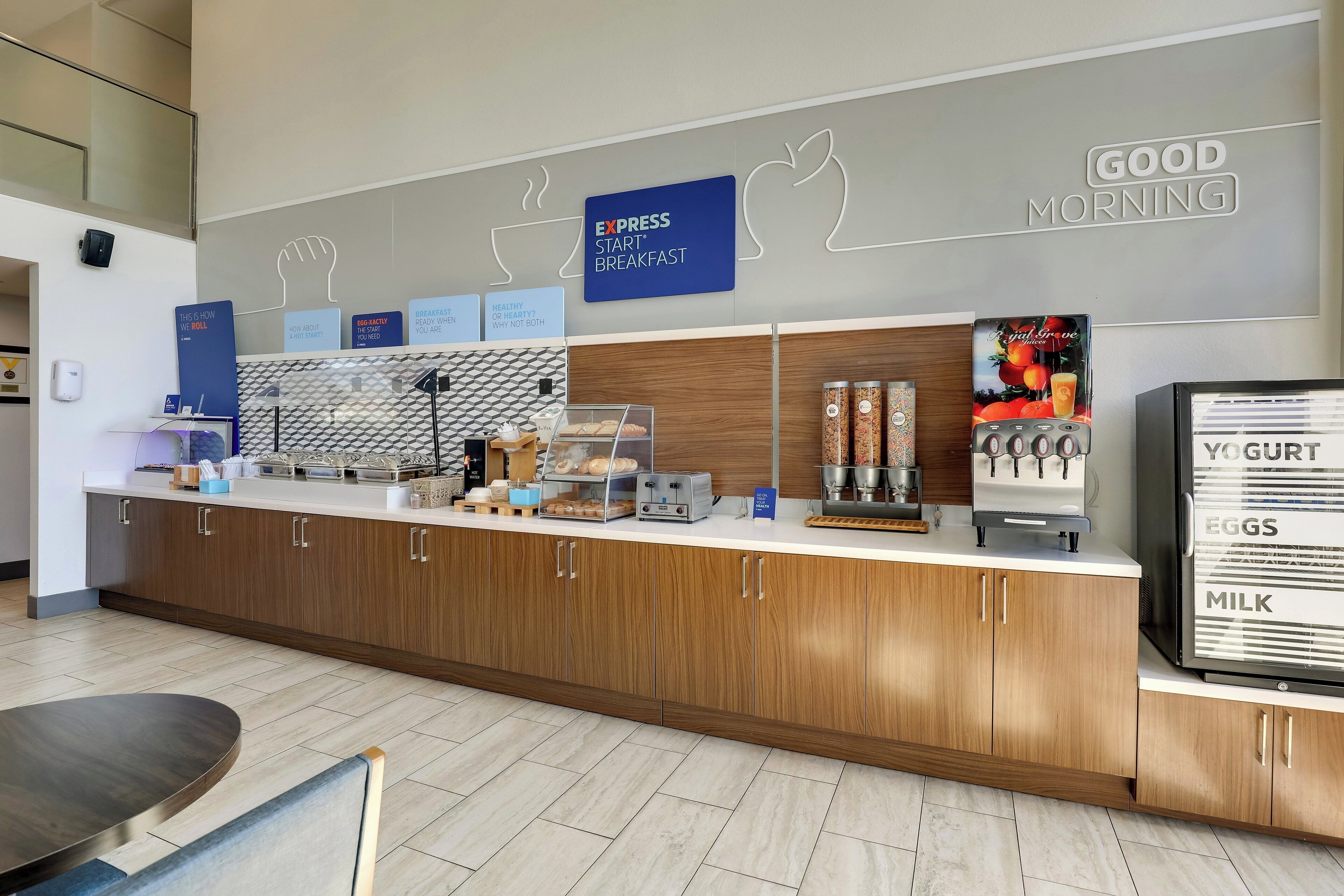 Een moderne ontbijtruimte met een houten aanrecht, een yoghurtdispenser en een koffiemachine.