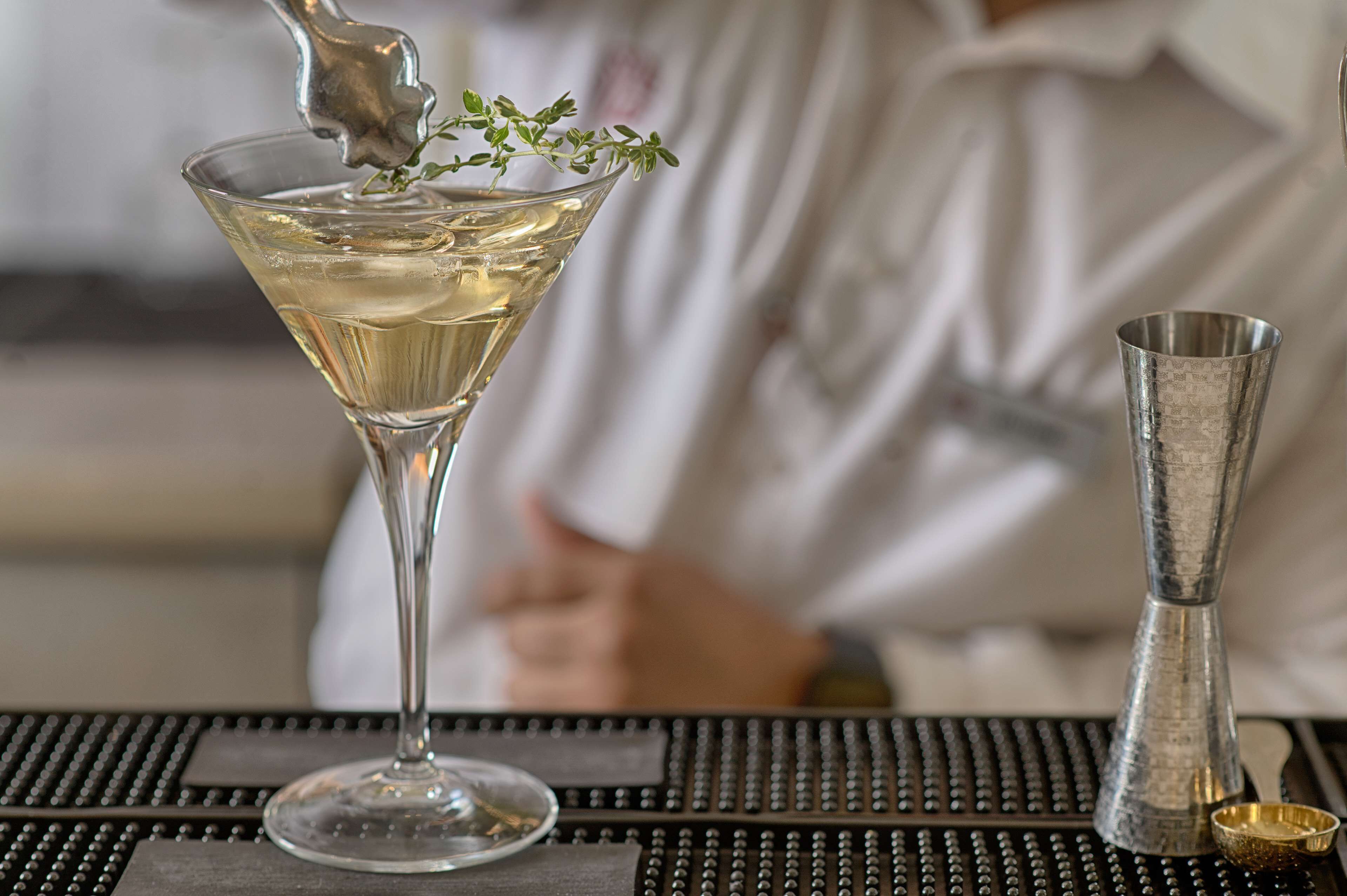 A martini glass with a garnish on a bar counter.