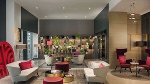 A modern living room with a central coffee table, sofas, and red accents. - NH Collection Milano Porta Nuova (Milan)