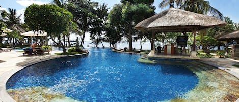 Una piscina al aire libre, sillones reclinables de piscina