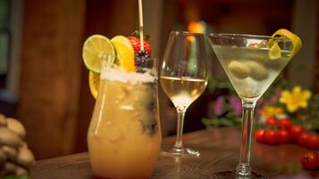 Two cocktails on a wooden table with a blurred background.