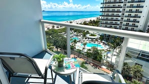 A balcony with a view of a beach and a pool area. - Best Western Plus Atlantic Beach Resort (Miami Beach)