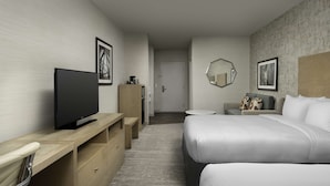 A hotel room with a bed, a TV, a desk, and a mirror.