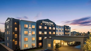 A DoubleTree by Hilton hotel with a modern design, multiple floors, and a parking lot with handicapped spaces.