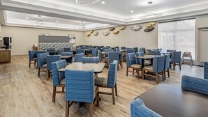 A spacious dining area with multiple tables and chairs, a modern ceiling design, and a large window providing natural light. - LeConte Hotel & Convention Center, an Ascend Collection Hotel (Pigeon Forge)