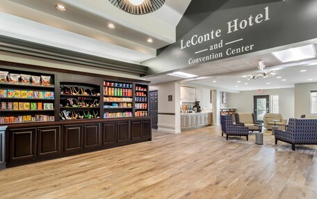 A hotel lobby with a reception desk, seating area, and a Convention Center sign.