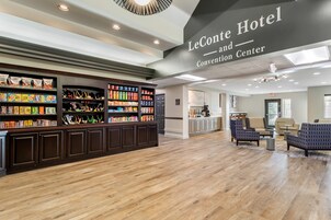 A hotel lobby with a reception desk, seating area, and a Convention Center sign.