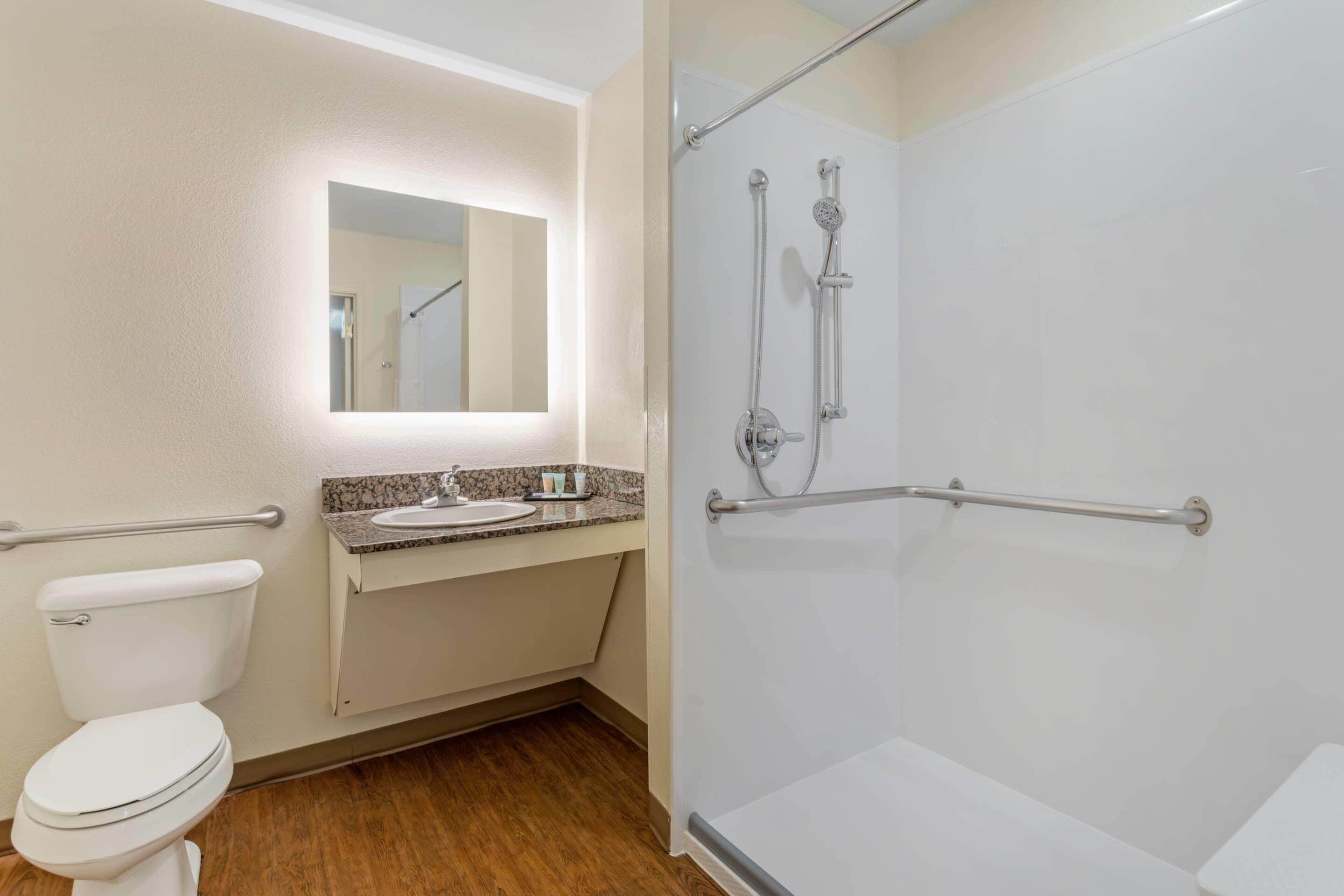 Une salle de bain avec des toilettes, un lavabo et une douche.