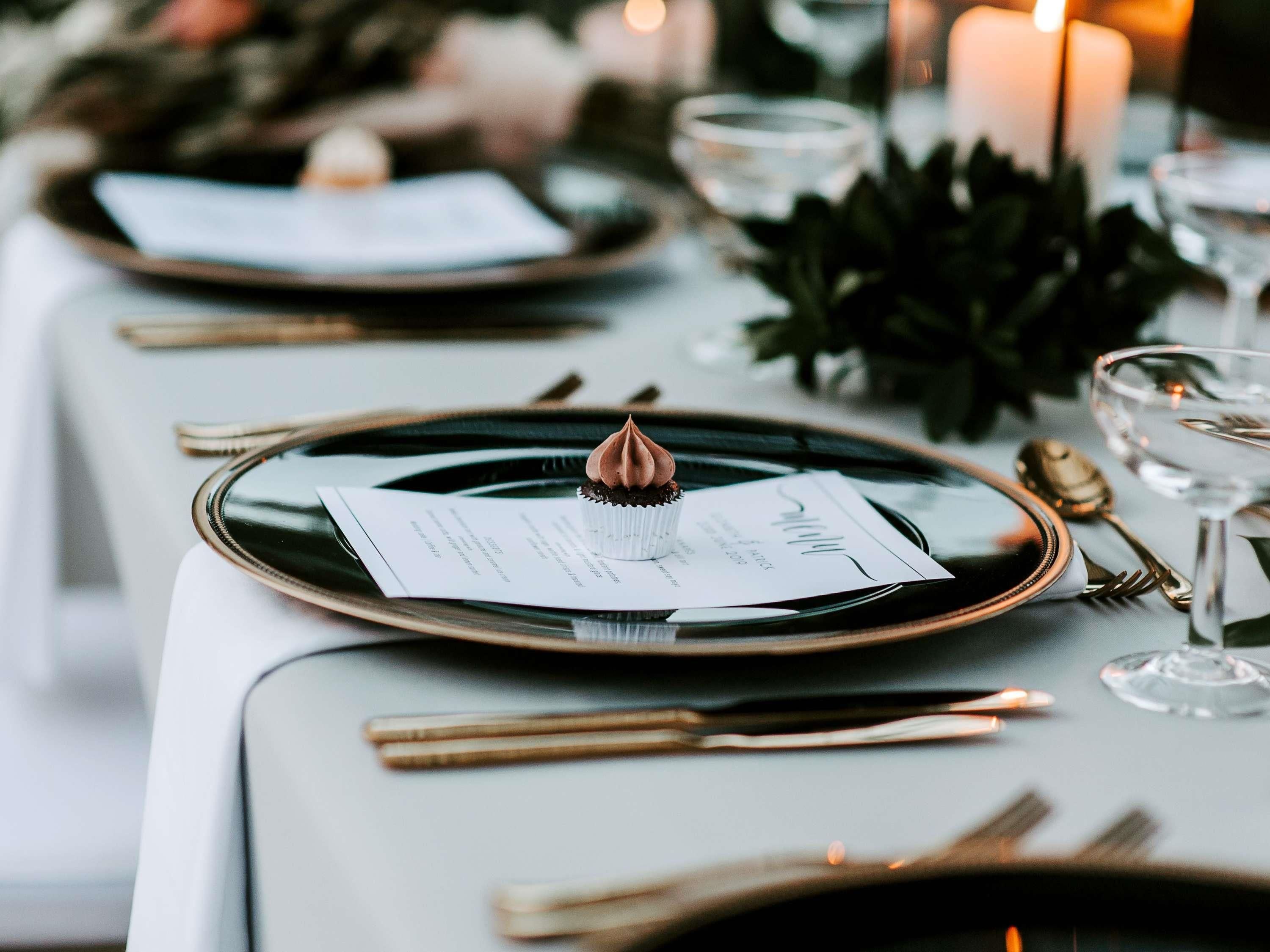 Une table dressée avec un dessert, un menu et des couverts.