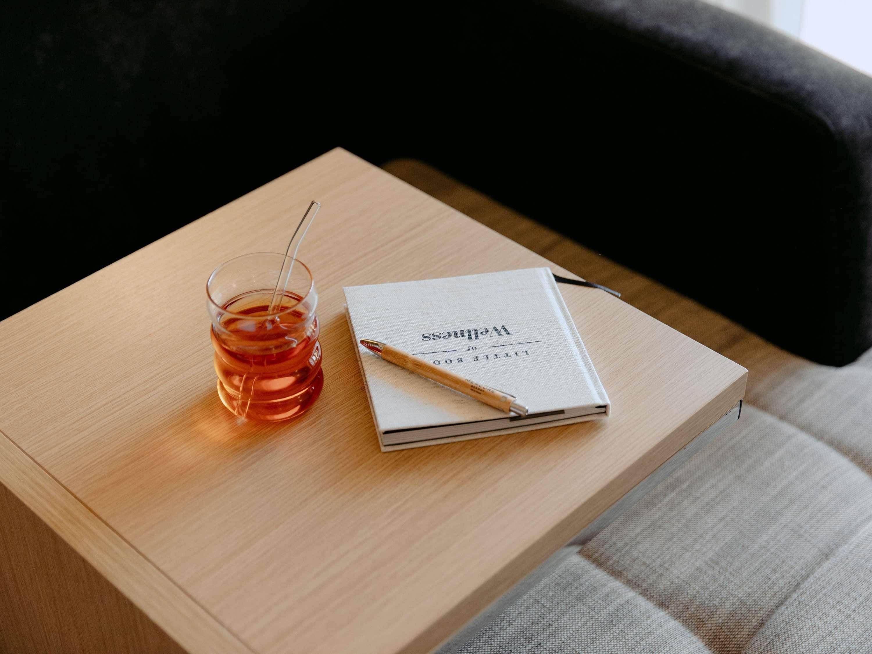 Una mesa de madera con un libro y una taza de té.