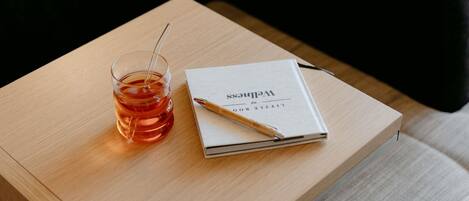 A wooden table with a book and a glass of tea.