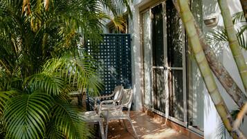 A patio area with a seating arrangement, a blue fence, and a large sliding glass door.
