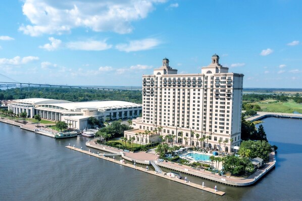 A high-rise hotel with a pool, located near a river with a bridge in the background. - The Westin Savannah Harbor Golf Resort & Spa (Savannah)