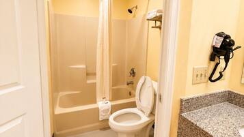Un baño con ducha, inodoro y lavabo.