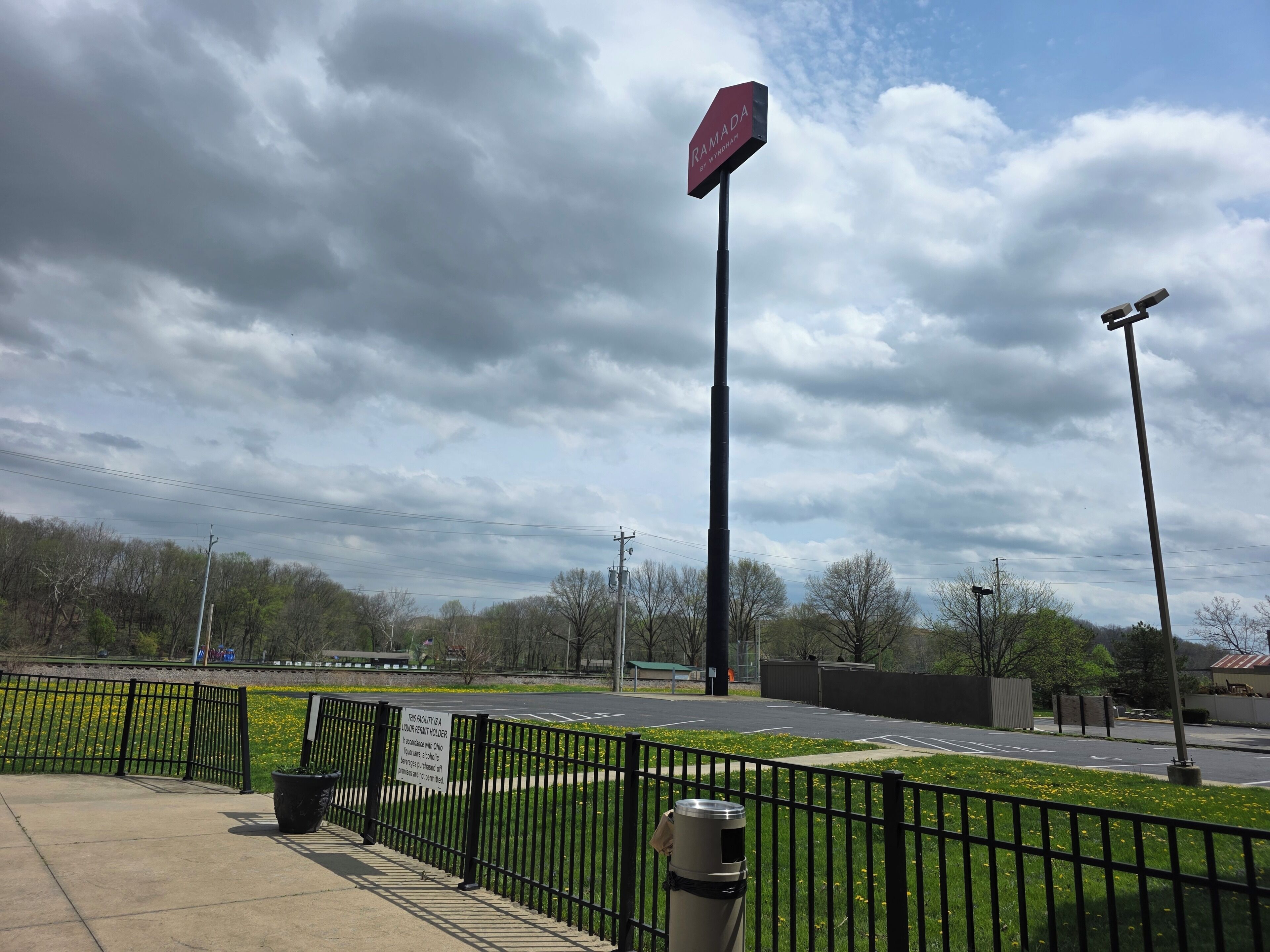 A parking lot with a sign indicating a facility for a liquor permit holder.