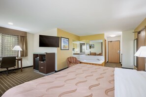 A hotel room with a bed, desk, chair, TV, and a mirror.