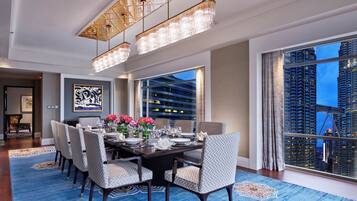 A dining area with a table set for six, large windows, and a view of a cityscape.
