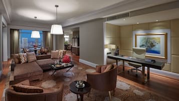 A modern living room with a sectional sofa, a dining area, and a workspace.