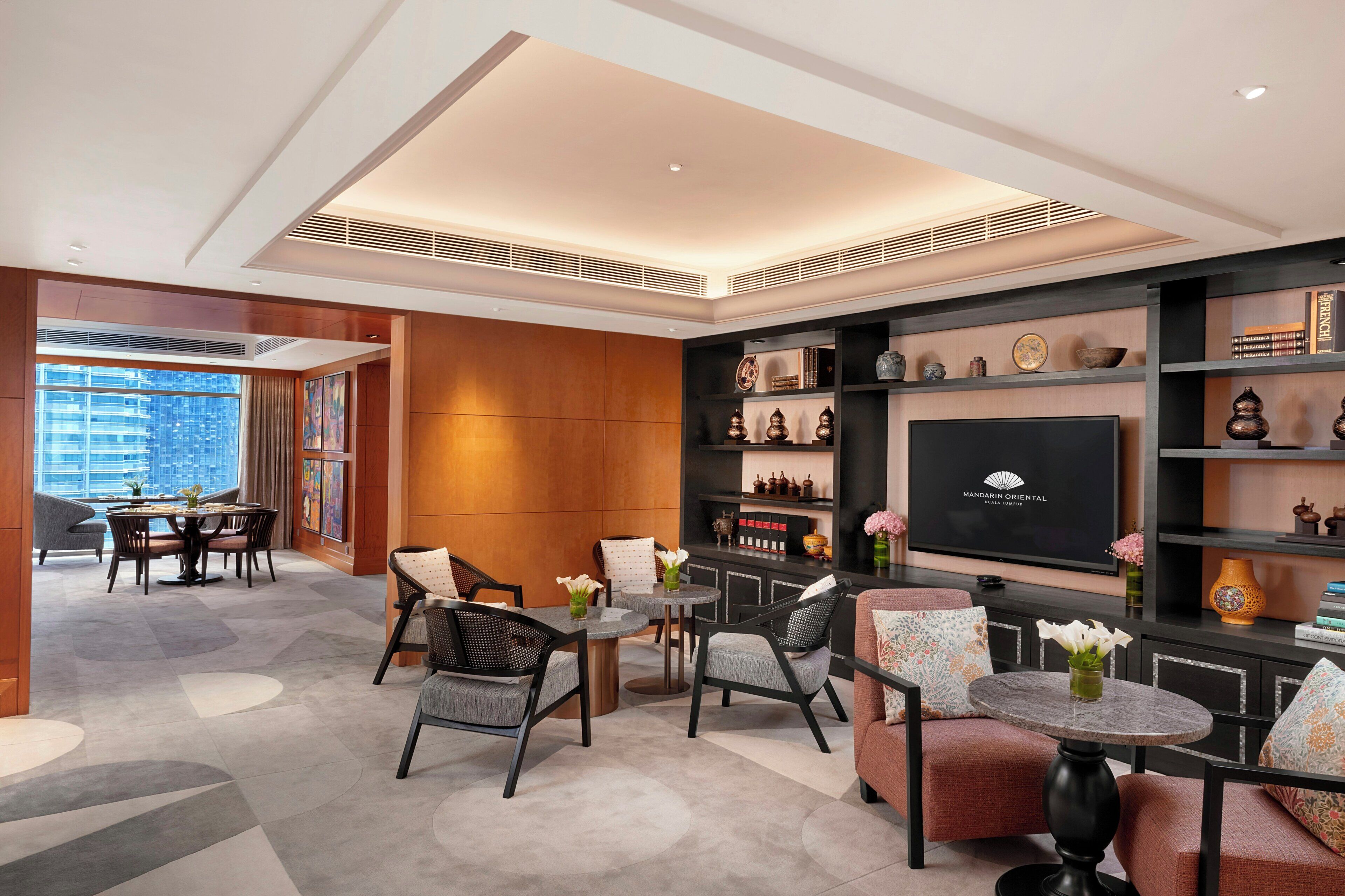 A modern lounge area with seating, a television, and decorative items.