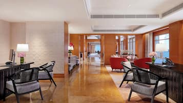 A hotel lobby with a reception desk, seating area, and a view of the cityscape through large windows.