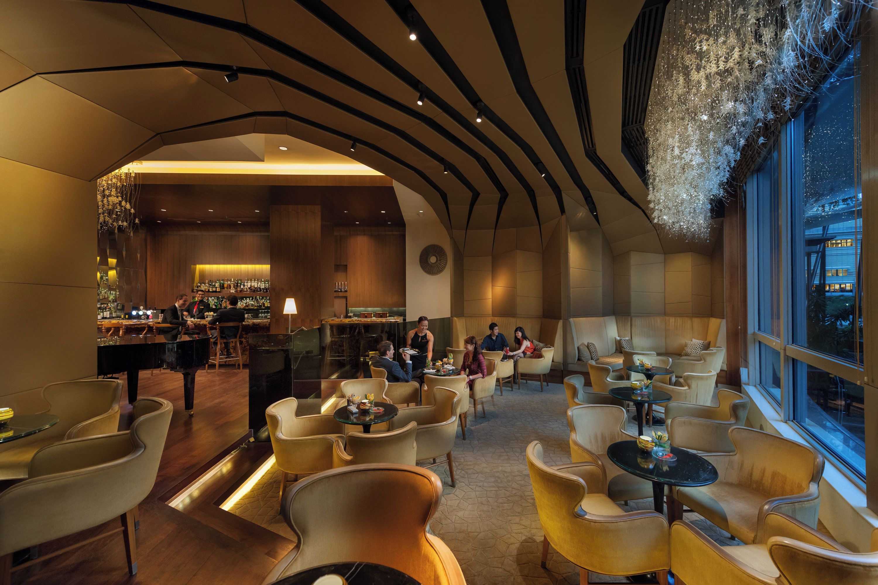 A modern interior with a bar area, seating arrangements, and a view through the window.