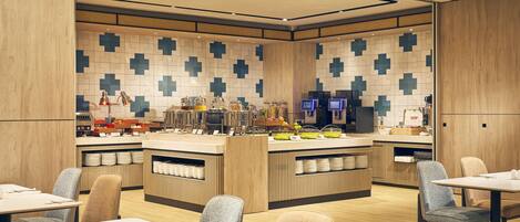 Un restaurante moderno con una isla central, varias zonas de estar y un salpicadero de azulejos.
