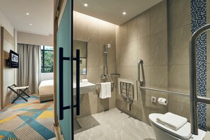 Een moderne badkamer met een douche, toilet en wastafel.