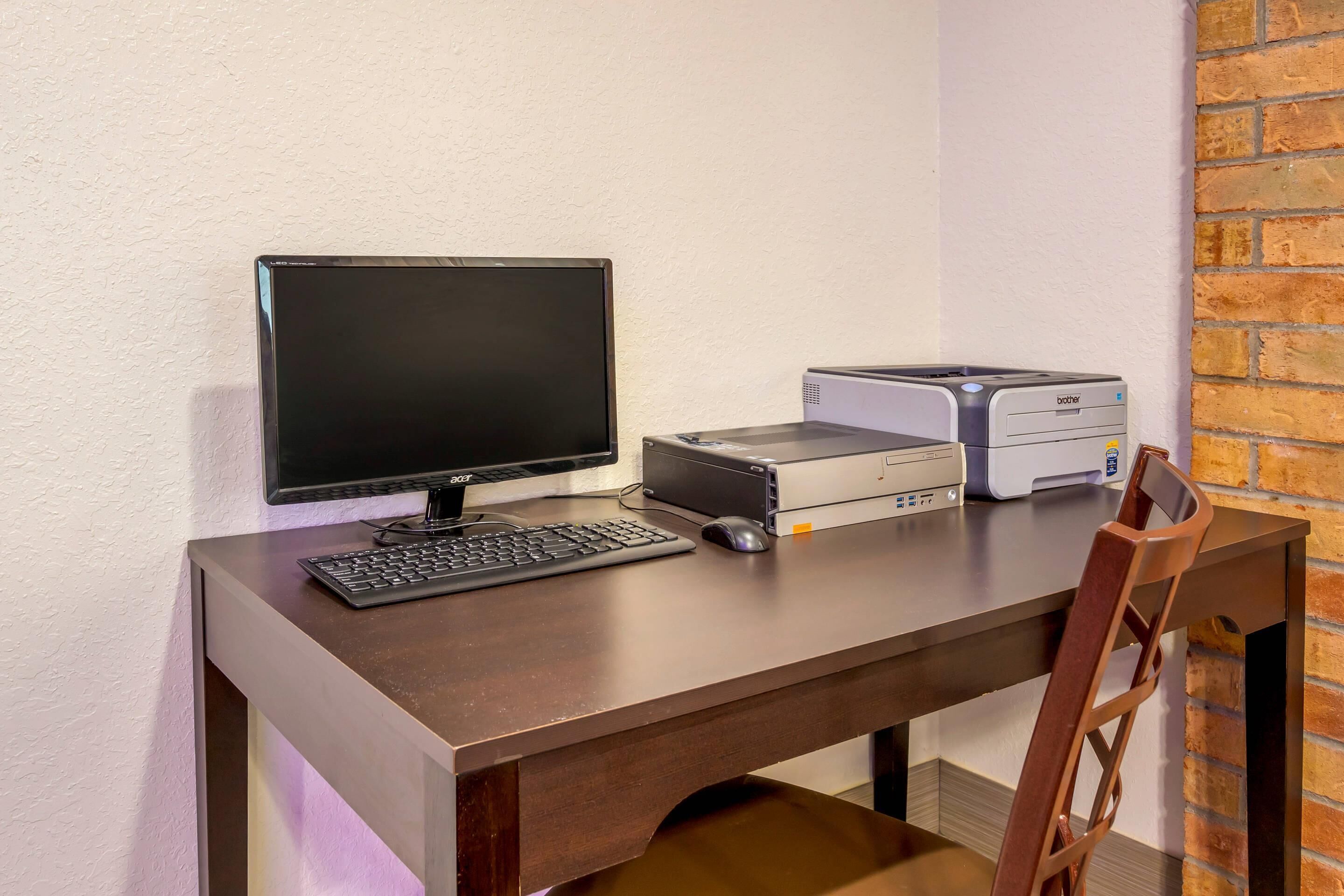Un escritorio con monitor, teclado, ratón e impresora.