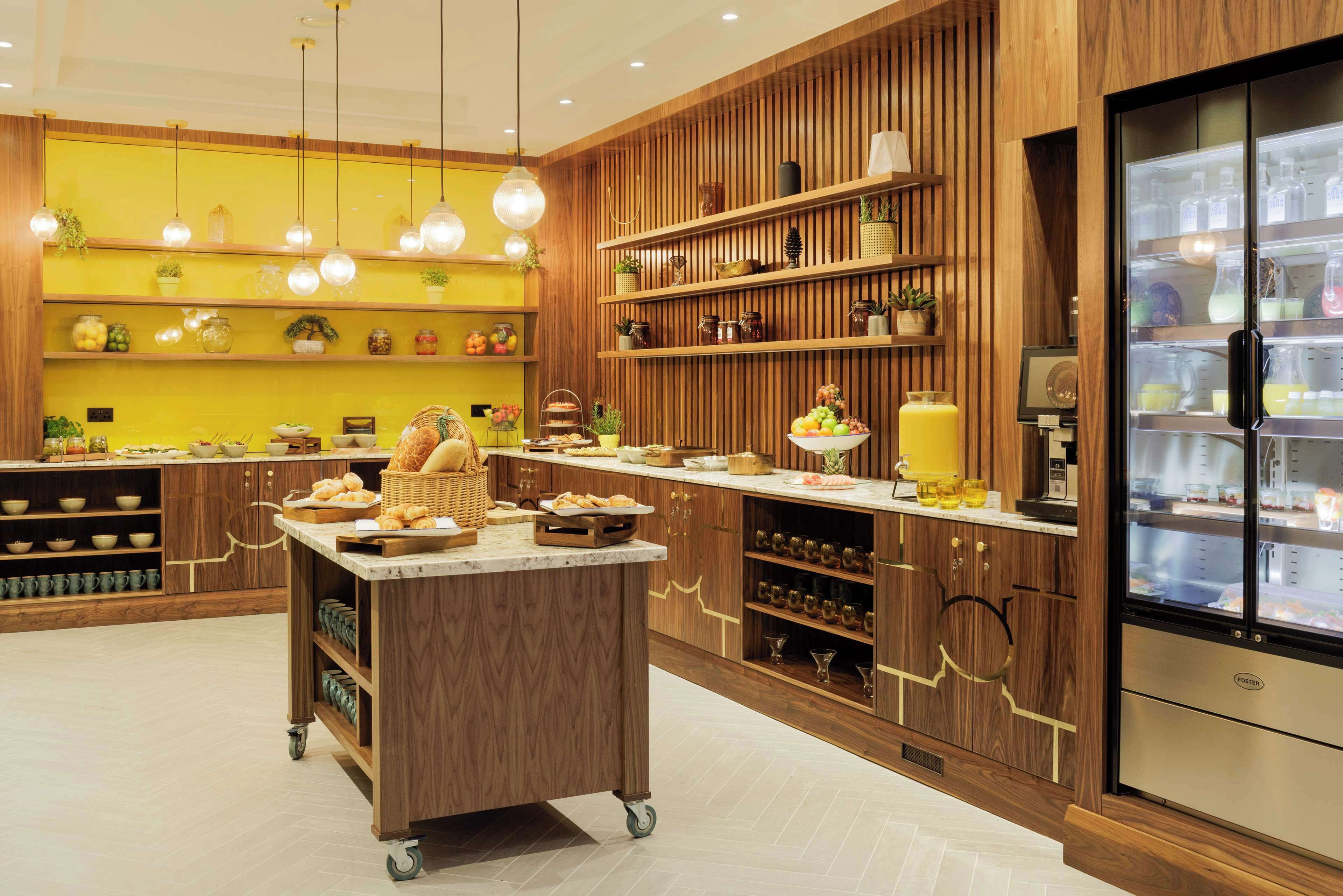 A modern kitchen with wooden cabinetry, a central island, and a built-in refrigerator.
