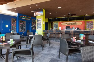 A restaurant with outdoor seating, a counter, and a menu board.