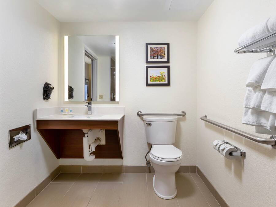 A modern bathroom with a toilet, sink, and towel rack.