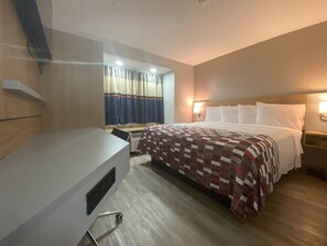 A hotel room with a bed, a desk, and a chair. - Red Roof Inn Winston-Salem (Winston-Salem)