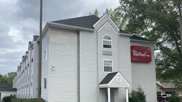 A hotel with a red sign reading "Red Roof Inn." It features a large, multi-story building with a prominent entrance and a small porch. - Red Roof Inn Winston-Salem (Winston-Salem)