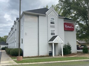 A hotel with a red sign reading "Red Roof Inn." It features a large, multi-story building with a prominent entrance and a small porch. - Red Roof Inn Winston-Salem (Winston-Salem)