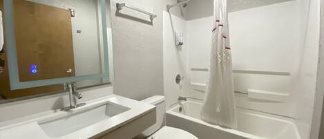 Une salle de bain avec un lavabo, des toilettes et une baignoire.