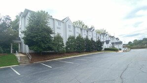 A multi-story residential building with a covered entrance and steps leading to the door. - Red Roof Inn Winston-Salem (Winston-Salem)