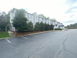 A multi-story residential building with a covered entrance and steps leading to the door.