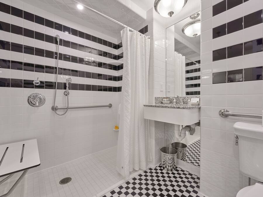 Uma casa de banho moderna com chuveiro, sanita e lavatório.